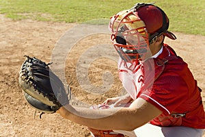 Baseball catcher crouching on field photo