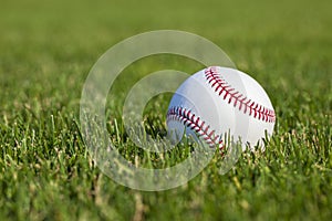 Baseball close up selective focus low angle in the outfield grass at a ballpark