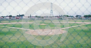 Baseball, empty field and fence in summer at arena, pitch and training park. Sports, lawn or stadium for softball