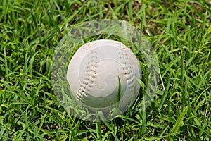 Baseball on the fresh green grass .