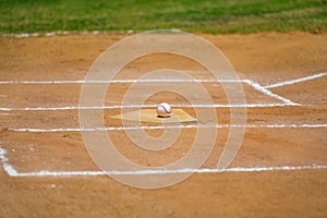 Baseball game, baseball ball sitting on the home plate, base, during the ball game