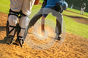 Baseball game, home plate umpire dusting of the home base during the ball game