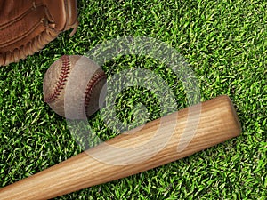 Baseball, glove, ball and bat on field
