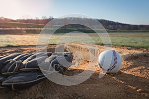 Baseball glove and ball on pitcher`s mound