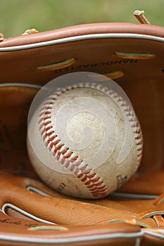 Baseball in a glove on a field