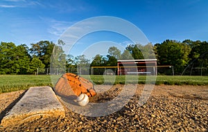 Baseball and glove on pitcher`s mound in early morning