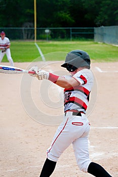 Baseball kid batting with a full swing.