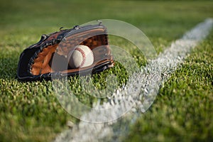 Baseball mitt and ball on field with white line