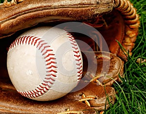 Baseball with mitt in grass