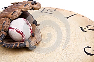 A baseball and mitt on an old vintage clock