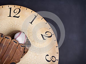 A baseball and mitt on an old vintage clock