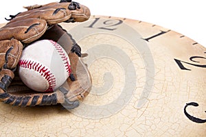 A baseball and mitt on an old vintage clock
