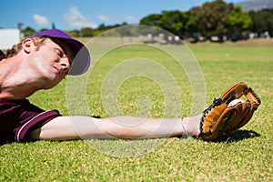 Baseball pitcher catching ball while diving on field