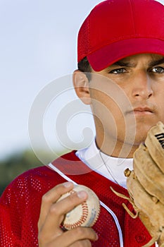 Baseball pitcher holding glove and ball