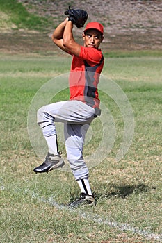 Baseball pitcher winds up to throw the ball photo