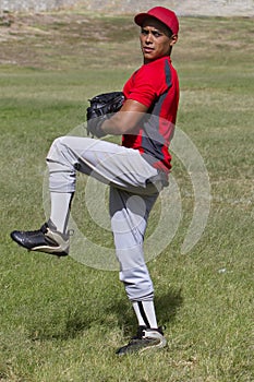 Baseball pitcher winds up to throw the ball photo