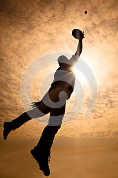 baseball player jumping into air to make the catc