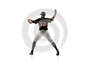 Baseball player, pitcher in a black uniform practicing on a white background.