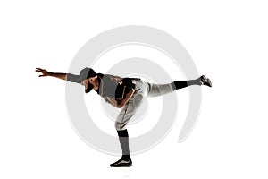 Baseball player, pitcher in a black uniform practicing on a white background.