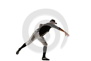 Baseball player, pitcher in a black uniform practicing on a white background.