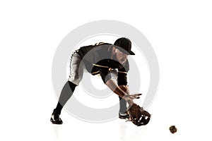 Baseball player, pitcher in a black uniform practicing on a white background.