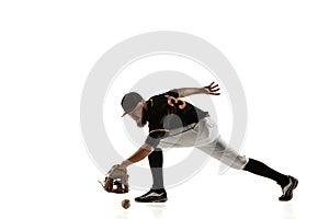 Baseball player, pitcher in a black uniform practicing on a white background.