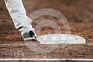 Baseball player with he's feet touching the base plate