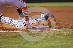 Baseball player sliding first base photo