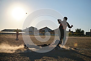 Baseball player sliding into base creating dust cloud