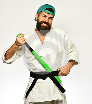 Baseball player with smiling face holds green baseball bat