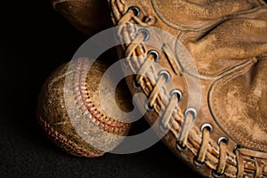 Baseball shadowed by old mitt with worn stitching and stained with years of games