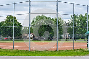 Baseball or softball diamond through a fence in  park in a small town Canadian city of Brighton near Pesquile Lake Provincial Park