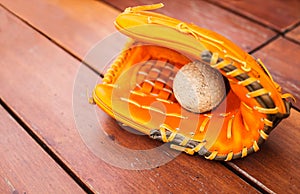 Baseball, Softball with leather mitt glove on wood table floor background with copy space. Sport Recreation Theme