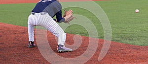 Baseball third baseman fielding a ground ball photo