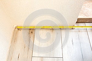 Baseboard installation. Repair works indoors. Renovation in the flat.  Tape measure