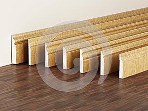 Baseboards with various profiles standing on hardwood surface. 3D illustration