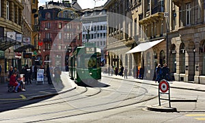 Green tram driving through the historic center Grossbasel. City of Basel, Switzerland