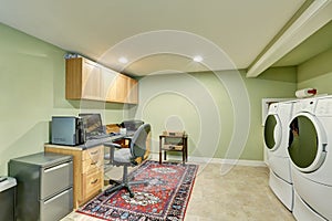 Basement room with home office area and laundry appliances