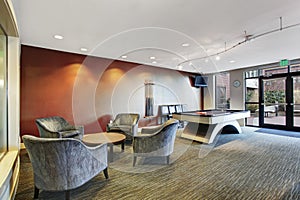 Basement room interior with comfortable chairs and biliards