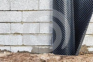 Basement wall waterproofing - installing dimple geomembrane photo