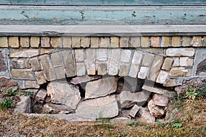 The basement window of an old stone and brick house filled with stones. History and construction