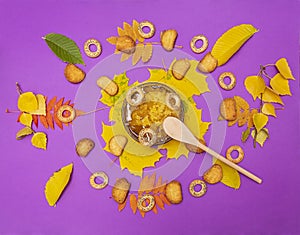 Bashkir honey is a sweet autumn treat on a purple background surrounded by yellow leaves and dryers