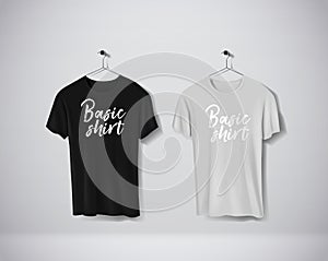 Basic Black and gray short sleeve T-Shirts Mock-up clothes set hanging isolated on wall. Front side view with lettering for your