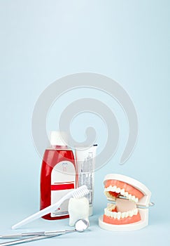 Basic dentist tools , toothbrush, toothpaste and Dental Teeth Model dentures on blue Dental background