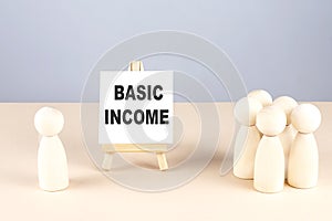 BASIC INCOME text on easel with wooden figure, meeting concept