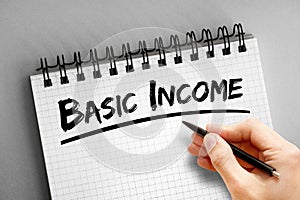 Basic income text on notepad, concept background