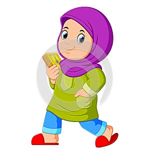 Moslem girl walking and carrying holy Quran photo