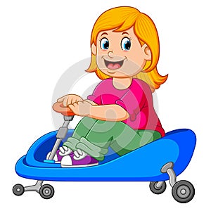 The girl is cycling on the blue tricycle