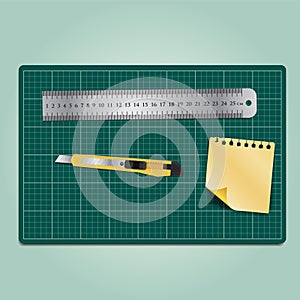 Working equipment ,cutter, ruler and paper on the green cutting mat