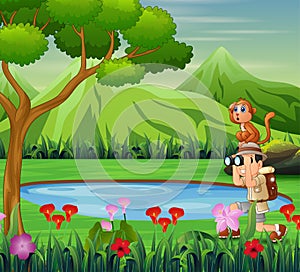 Boy using binoculars with a monkey near the small pond